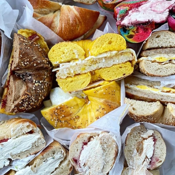 A close-up of various bagels from The Bagels, including breakfast sandwiches and cream cheese.